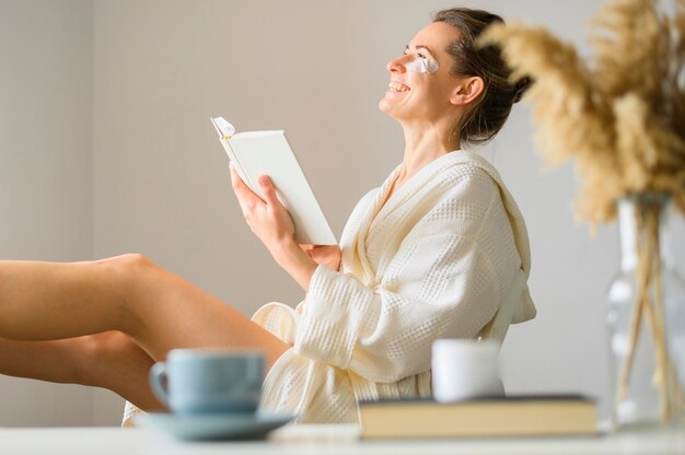 Side view of woman with eye patches reading a book