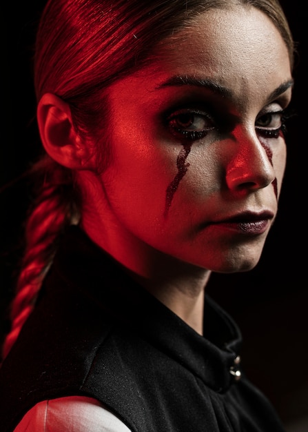 Free photo side view of woman with fake blood make-up