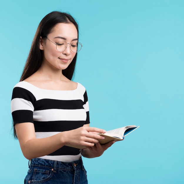 Free photo side view woman with glasses reading