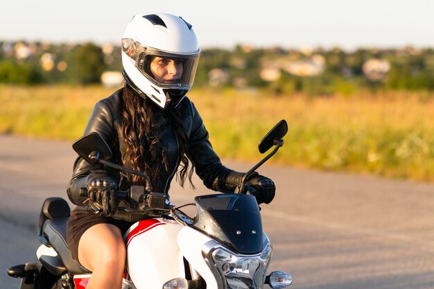 Side view of woman with helmet on riding motorcycle