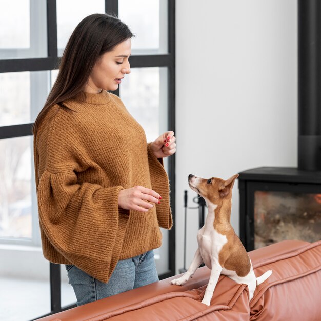 Вид сбоку женщины с ее собакой на диване