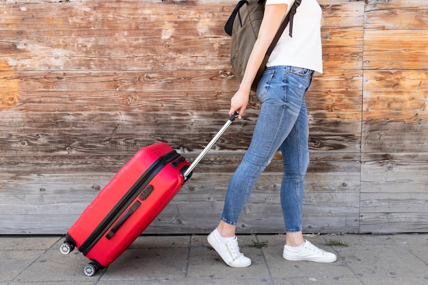 Free photo side view of woman with her luggage