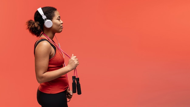 Free photo side view woman with jumping rope