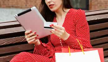 Free photo side view of woman with laptop and credit card purchasing online