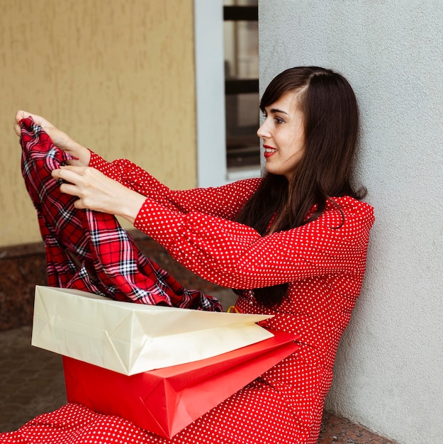 Side view of woman with shopping bags and sale clothing