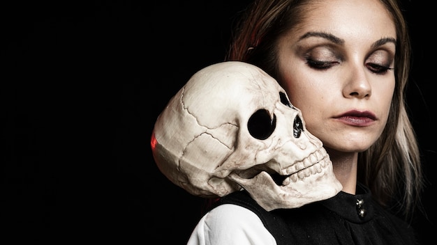 Free photo side view of woman with skull and copy space