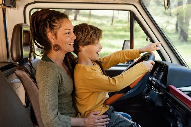 Side view woman with son in her lap driving