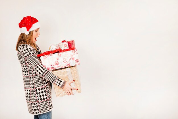 Side view of woman with stack of presents