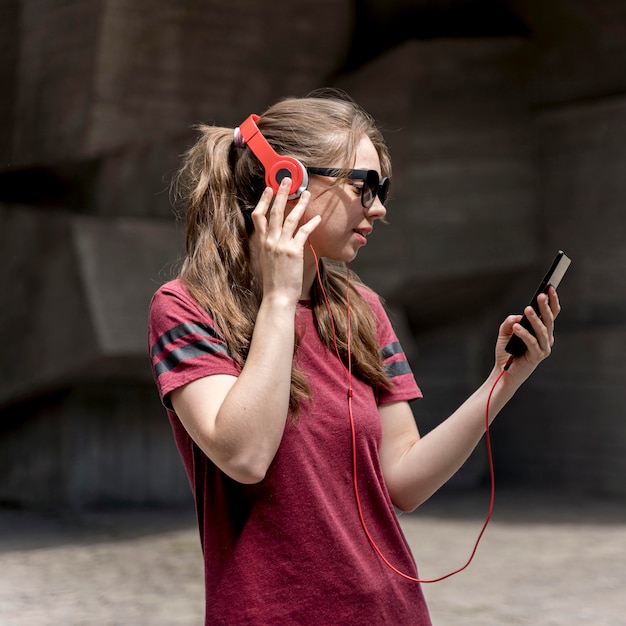 Side view woman with sunglasses listening music