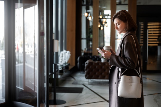 Foto gratuita donna di vista laterale al lavoro con la tazza di caffè