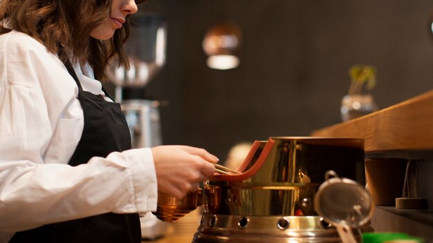 Side view woman working in coffee shop