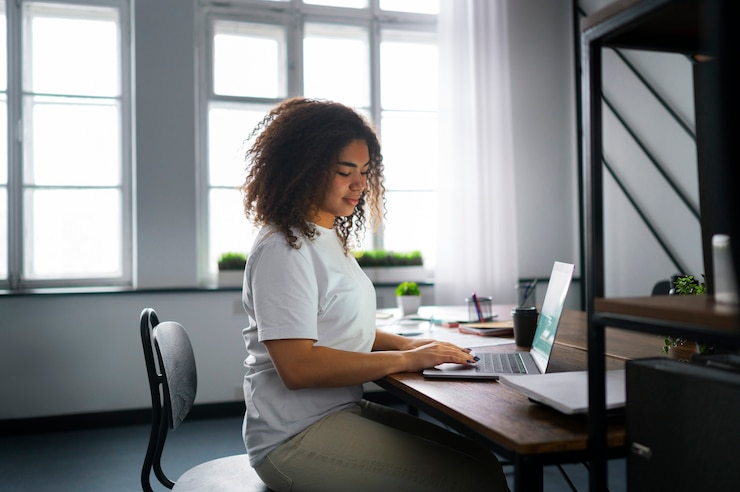 Free Photo side view woman working at desk