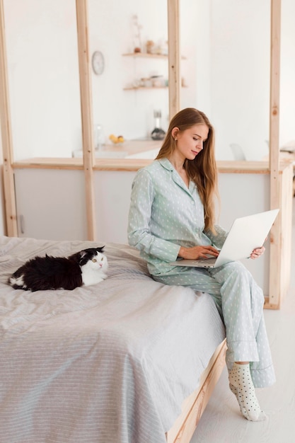 고양이와 잠옷에 집에서 일하는 여자의 모습