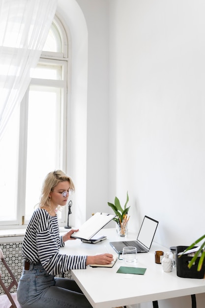 Free photo side view woman working from home