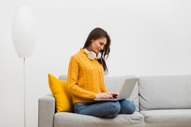 Side view of woman working at laptop on her couch
