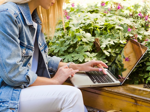 Side view of woman working on laptop outdoors