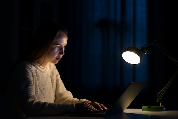 Вид сбоку женщины, работающие на ноутбуке
