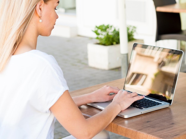 Free photo side view of woman working on laptop