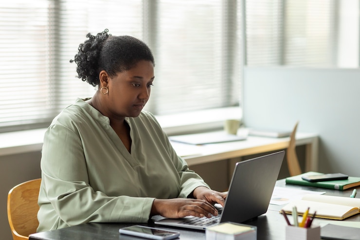 Free Photo side view woman working on laptop