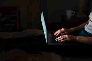 Free photo side view of woman working late at home on laptop