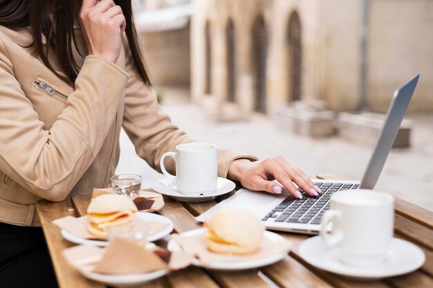 Side view of woman working outdoors and having lunch