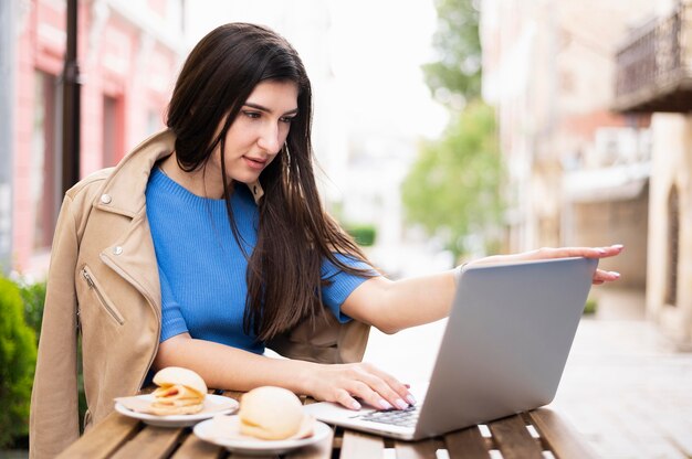 昼食をとりながら屋外で働く女性の側面図
