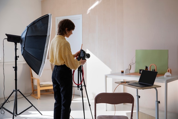 Foto gratuita vista laterale donna che lavora in studio fotografico