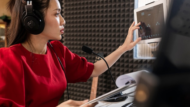 Side view woman working at radio with professional equipment