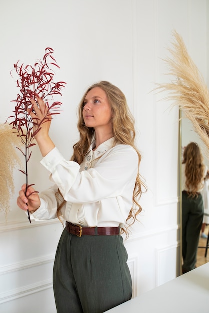 Free photo side view woman working with dried flowers