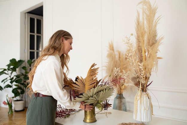 Side view woman working with dried flowers
