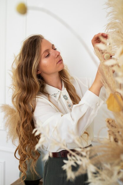 Side view woman working with dried plants