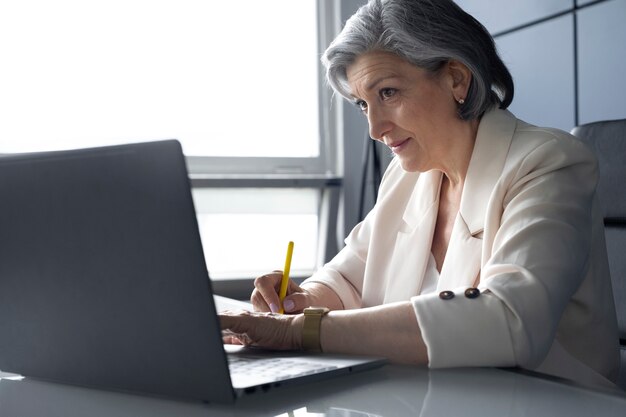 ノートパソコンで作業する側面図の女性