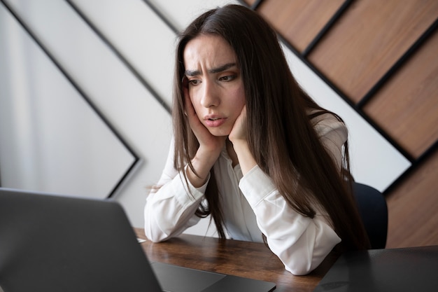 Foto gratuita donna di vista laterale che lavora con il computer portatile