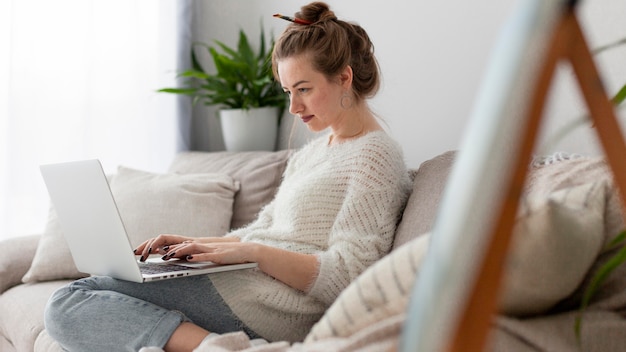 Side view woman writing a blog at home