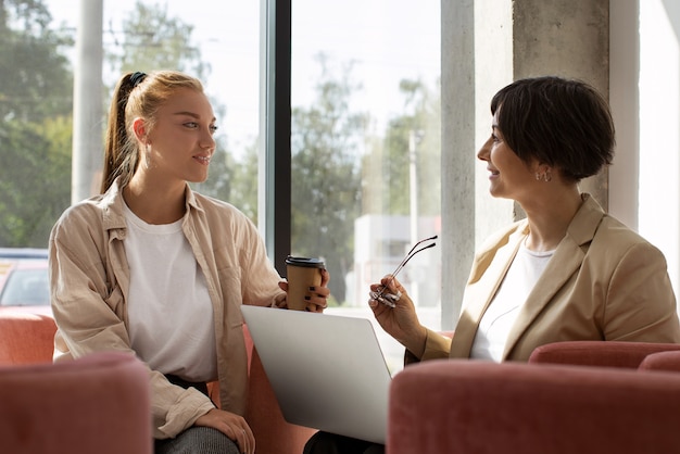 Side view women discussing at work