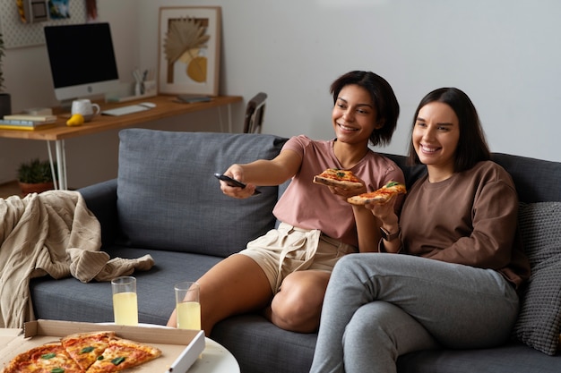 Free photo side view women eating delicious pizza