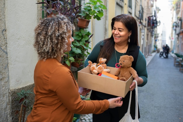 Free photo side view women exchanging items