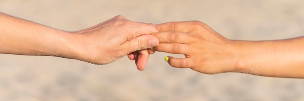 Free photo side view of women holding hands on beach while working out