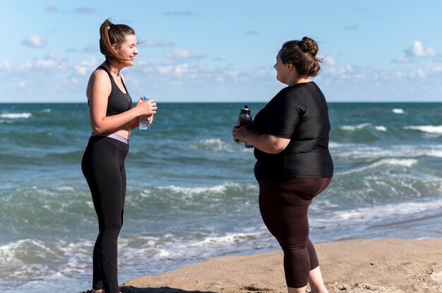 Side view women holding water bottles