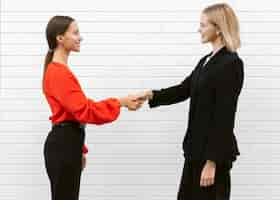 Free photo side view of women saluting each other