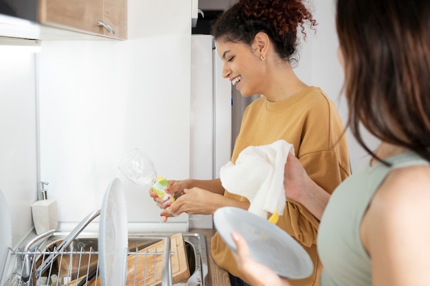 Donne di vista laterale che lavano i piatti