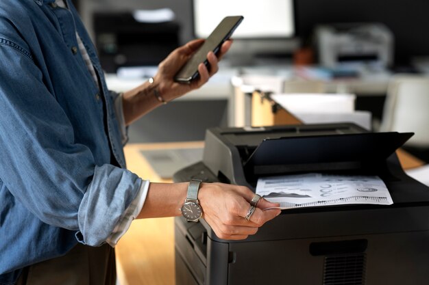 Side view worker holding smartphone