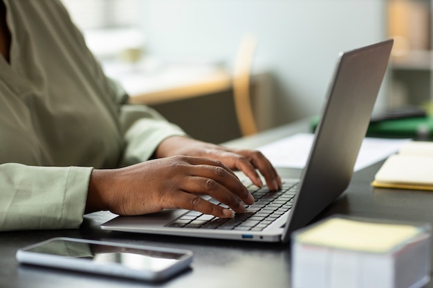 Side view worker typing on laptop