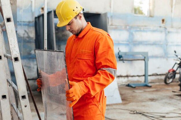 Side view of worker in uniform with hard hat and protective gloves