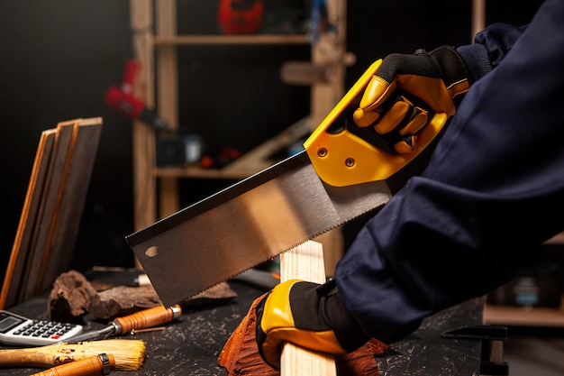 Side view worker using saw