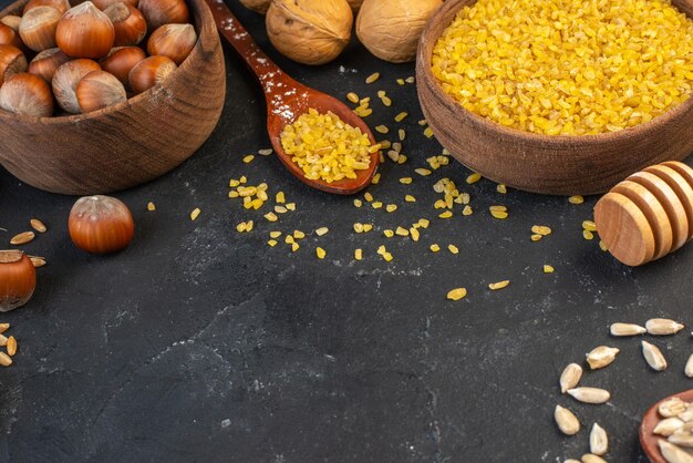 Side view of yellow rice hazelnuts walnuts eggs spikes on dark color background with free space