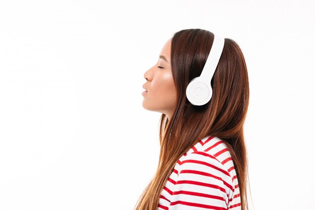 Side view of a young asian girl in headphones