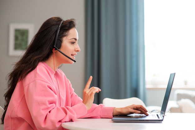 Side view young blogger using headset and laptop