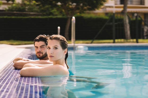 Free photo side view of young couple in pool