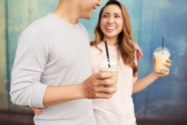 ミルクセーキとのデートでロマンチックな散歩をしている若いカップルの側面図